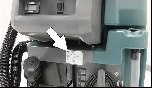 Photo of the machine with an arrow pointing to the serial number label below the control panel