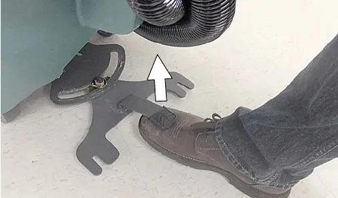Foot lifting the squeegee pedal to raise the mount bracket