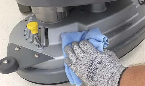 Wiping the scrub head with a damp cloth