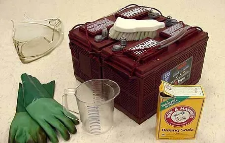 Battery with a scrub brush, baking soda, a measuring cup, gloves and safety glasses