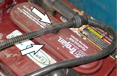 Arrows pointing to hoses and fittings on top of the batteries