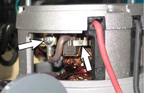 Arrows pointing to the pan screw and spring clip holding the carbon brush inside the motor