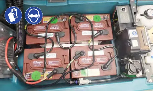 Battery compartment with four batteries and the watering system hoses, with gloves and eye protection symbols