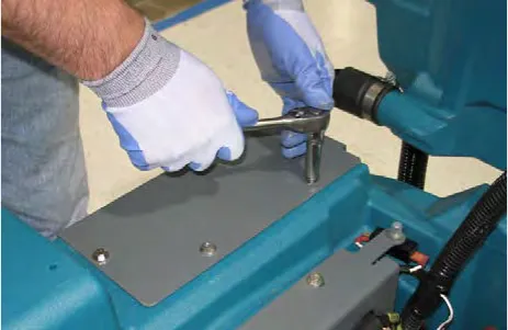 Gloved hand removing the charger cover bracket