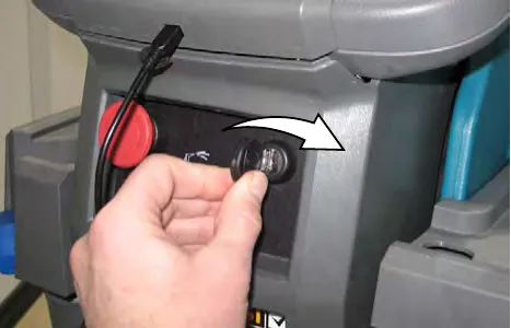 Hand turning the key switch clockwise to the ON position