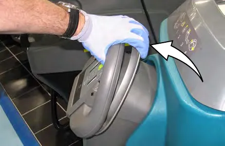Hand holding the machine while the bail handle is squeezed, with an arrow showing the bail handle movement