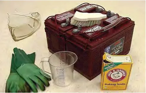A battery with a scrub brush, baking soda, a measuring cup, safety glasses and gloves