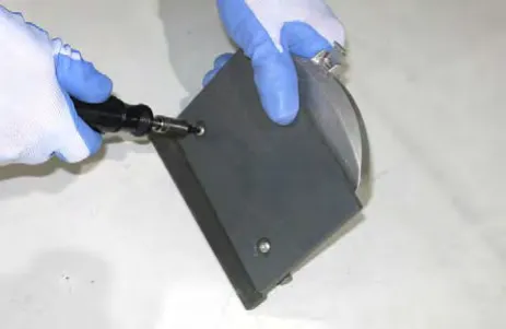 Hand removing the skirt cover from the idler plate