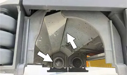 Underside of the cylindrical scrub head with arrows pointing to the idler plates and drive hubs