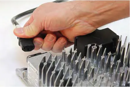 Hand unplugging the power cable from the charger
