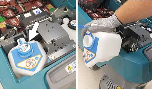 Arrow pointing to the automatic battery watering tank, and the tank being lifted out of the machine
