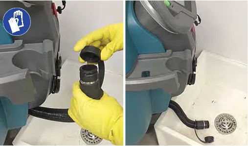 Draining the recovery tank hose into a floor drain while wearing gloves