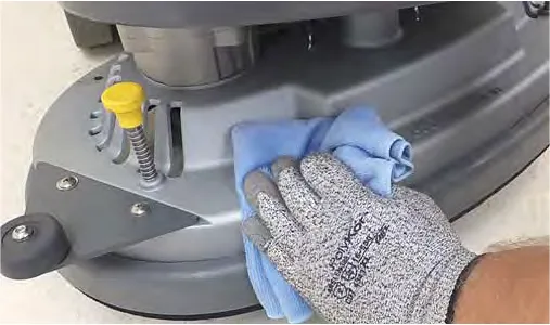 Wiping the scrub head with a damp cloth