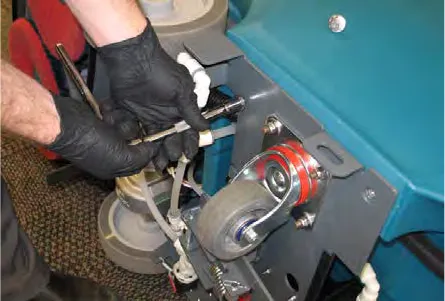 Gloved hands removing the hex screws that hold the rear frame