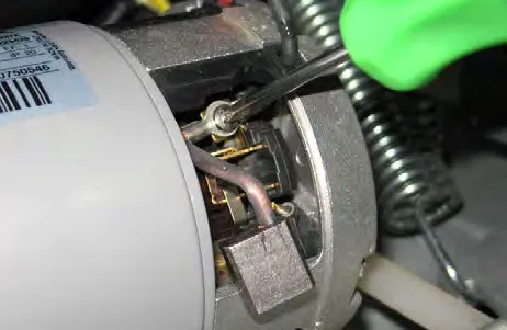 Carbon brush assembly being removed from the brush motor