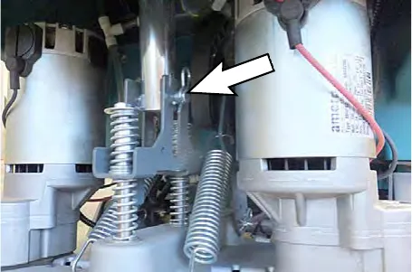 Arrow pointing to the clevis pin securing the actuator to the head suspension spring bracket