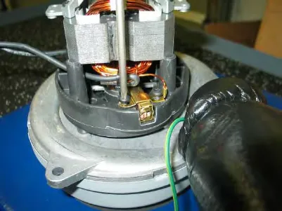 Vacuum fan motor with the carbon brush mounting hardware visible