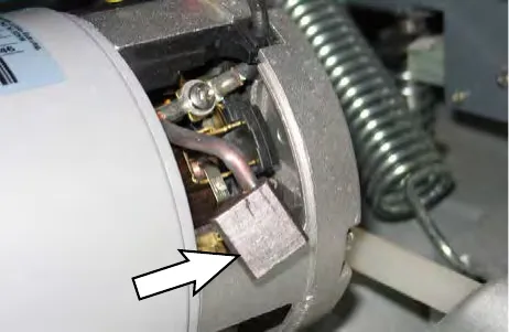 Arrow pointing to the carbon brush in the brush motor