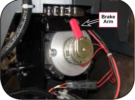 Close-up photo of the drive wheel motor brake with the red brake arm labeled Brake Arm
