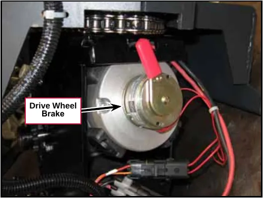 Photo of the drive wheel brake on the end of the drive wheel motor, with red wires and a connector below it