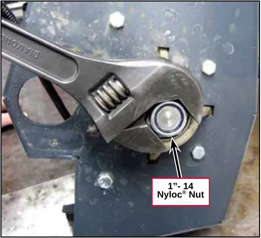 Photo of an adjustable wrench on the 1 inch-14 Nyloc nut on the spindle
