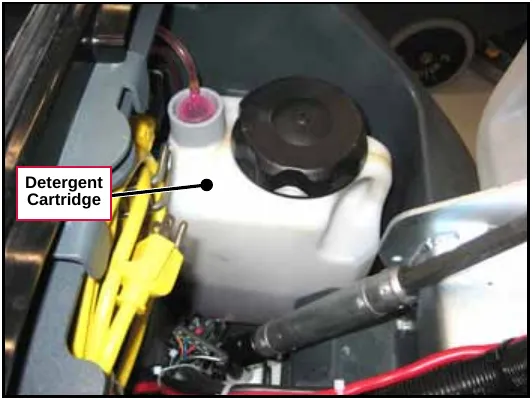 Photo of the white detergent cartridge with its black cap and pink detergent tube. Label: Detergent Cartridge.