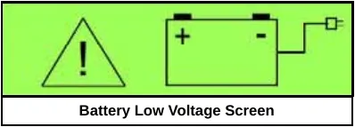 Green graphic display showing the battery low voltage screen: a warning triangle with an exclamation mark next to a battery icon with plus and minus terminals
