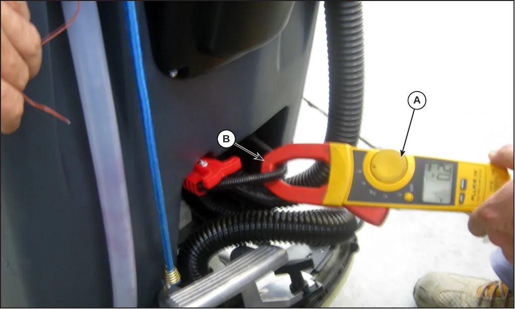 Amperometric clamp (A) applied around a battery cable (B) on the machine