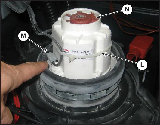 Vacuum motor (N) with its strap (L) and power supply connector (M)