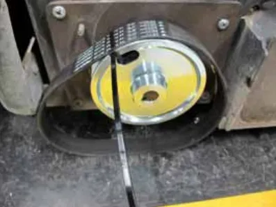 Photo of the new belt placed on the large pulley and held with a plastic wire tie