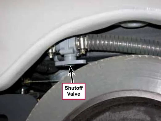 Photo looking at the left rear wheel well with a callout and arrow pointing to the Shutoff Valve underneath the solution tank