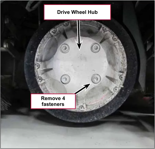 Photo of the front drive wheel seen from the side with the drive wheel hub facing out; arrows point to the drive wheel hub and to the 4 fasteners in its center to remove