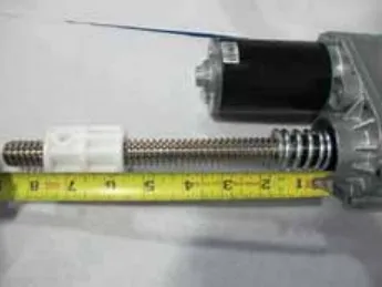 Photo of the actuator with a tape measure showing the drive nut about 5 1/2 in from the motor housing in the extended position