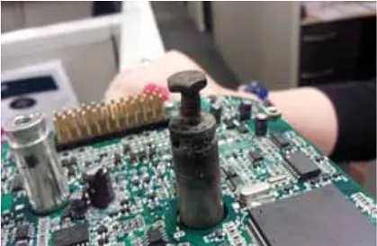 Close-up photo of a controller circuit board with a damaged, dark-colored lug where a cable terminal was attached