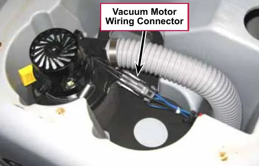Photo looking into the recovery tank cavity with a label and arrow pointing to the Vacuum Motor Wiring Connector beside the vacuum hose