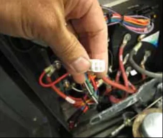 Hand holding the programmer connector in the electrical panel