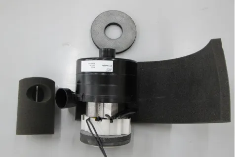 The removed vacuum motor on a bench with its three foam pieces laid out around it: a ring on top, a sleeve on the left and a curved sheet on the right