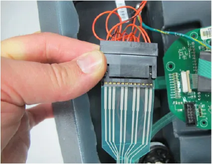 Hand holding the ribbon strip connector unplugged from the back of the rocker switches