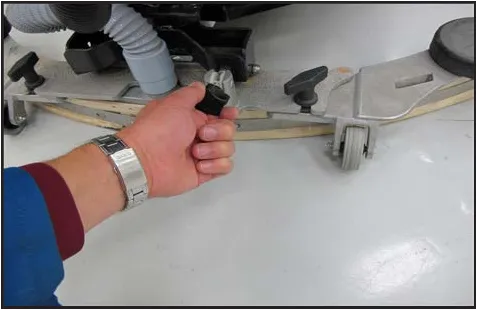 Photo of a hand turning the squeegee tilt adjustment knob on the squeegee tool