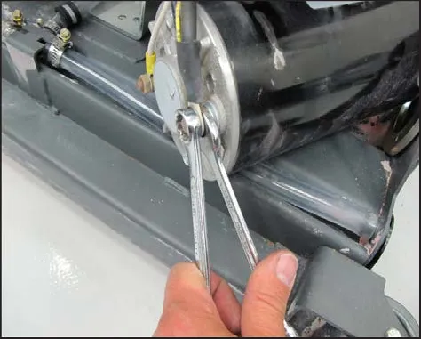 Two wrenches on the motor terminal, one holding the terminal while the other turns the nut