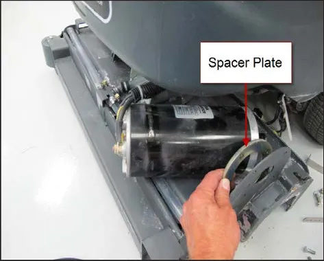 Motor partly slid out of the brush head with a hand holding the round spacer plate, labeled Spacer Plate