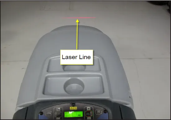 View of the machine from behind showing a red laser line on the floor ahead of it, with an arrow from the label “Laser Line”