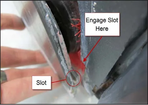 Close view of the idler cover edge with the slot circled and labeled Slot, and an arrow labeled Engage Slot Here pointing to the brush head