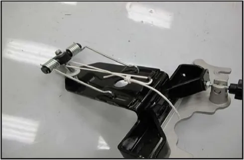 Squeegee support assembly lying on the floor with a wire tying up the spring tension