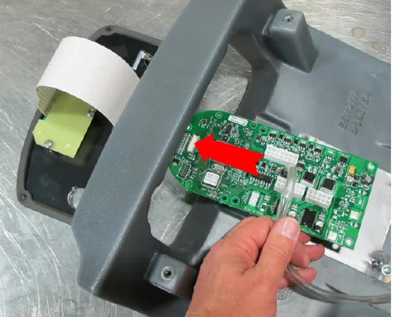 Circuit board held over the cover with a large red arrow pointing to the fitting where the clear pressure sensor tube attaches