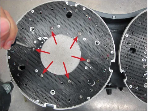 Photo of the underside of the deck with the pad holder center plate and red arrows pointing to the six attaching screws.