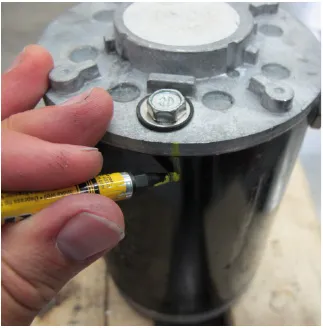 Photo of a marker drawing an orientation mark across the end plate and motor housing.