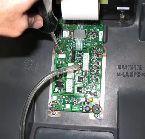 Circuit board in the inside of the cover with the clear pressure sensor tube attached and the four board mounting screws circled in red