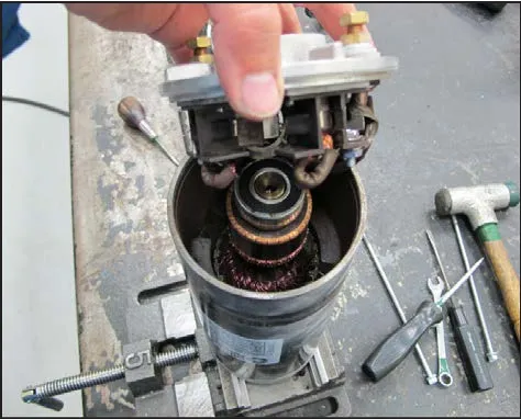 Endplate assembly lifted off the motor, showing the carbon brushes and commutator