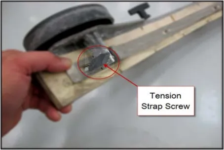 Photo of a hand holding the end of the squeegee tool with a circle and arrow from the label Tension Strap Screw
